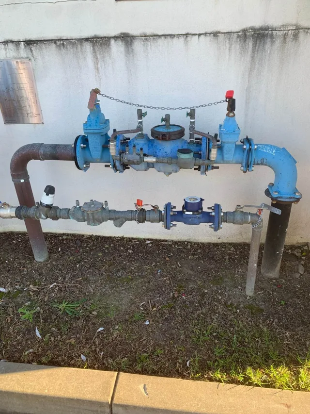 Backflow prevention device and connected pipework outside a building
