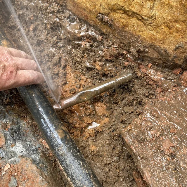 Exposed water pipe in the ground during a leak repair