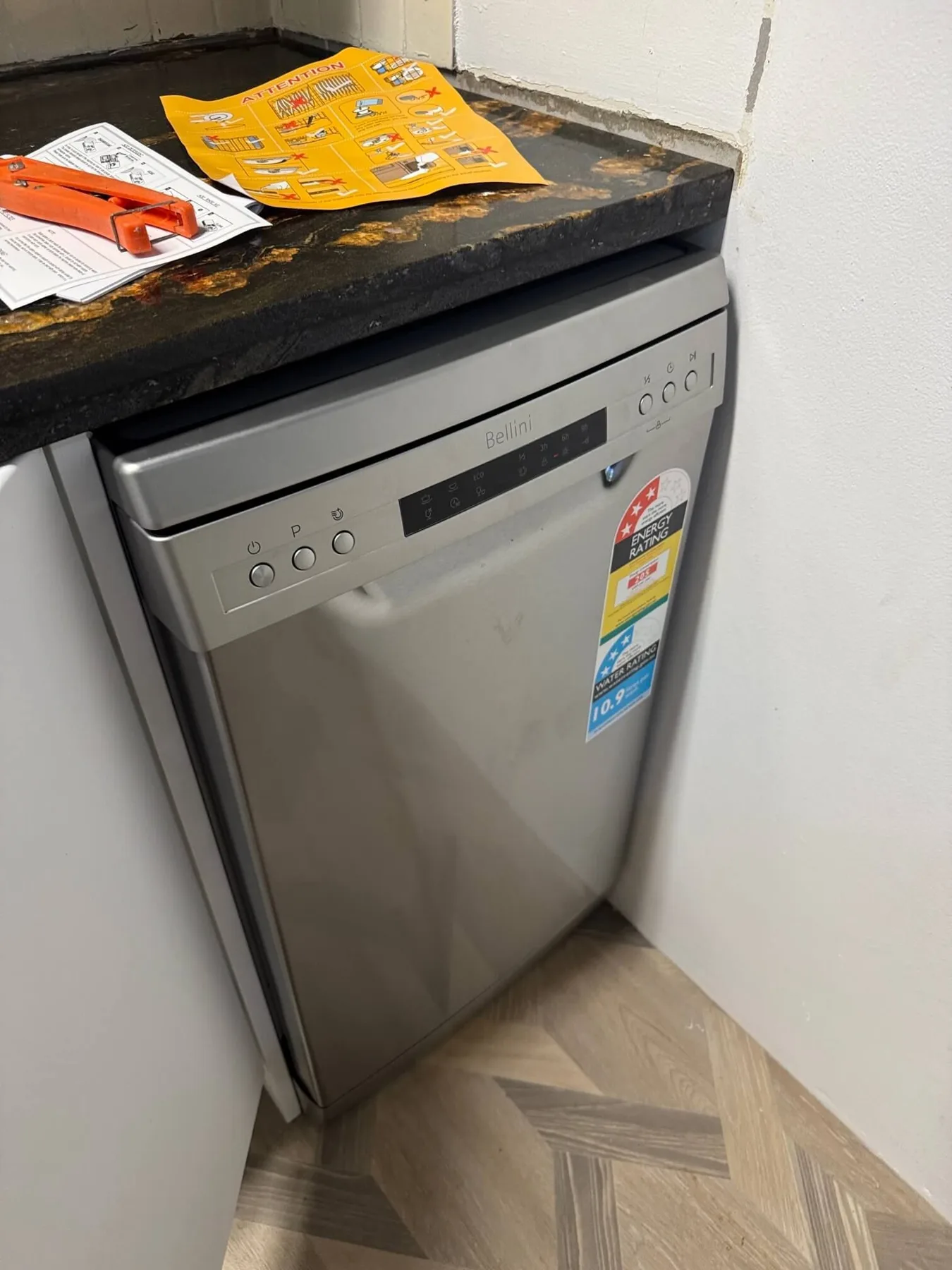 Stainless steel dishwasher installed beneath a kitchen bench