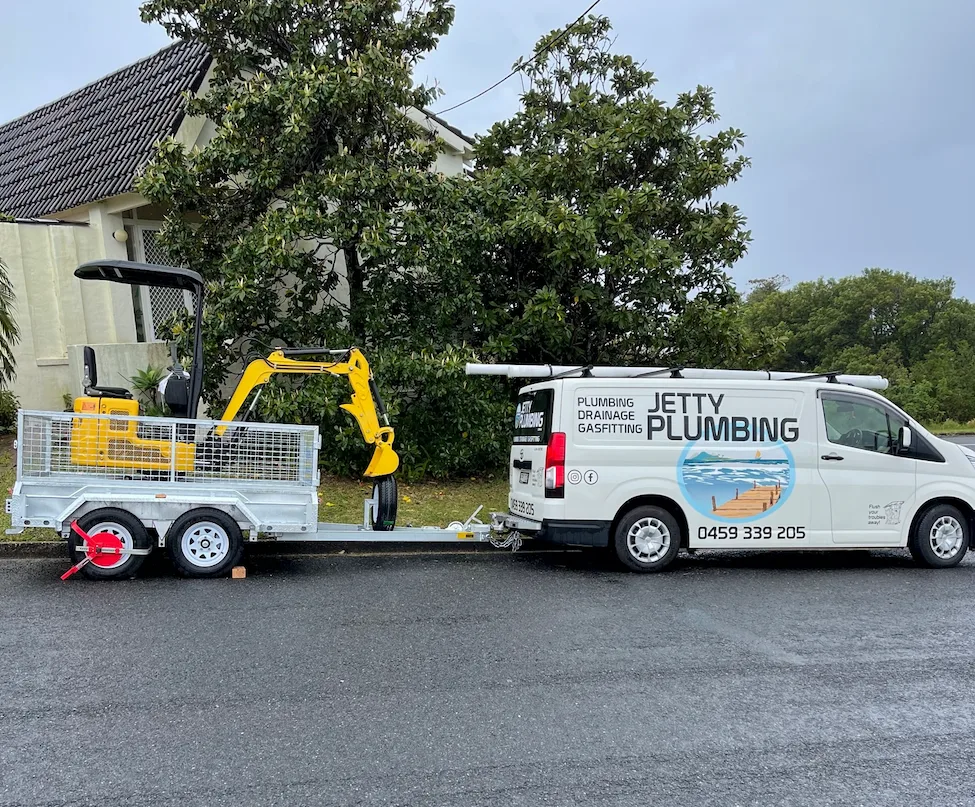 Jetty Plumbing service vehicle with a compact excavator on a trailer