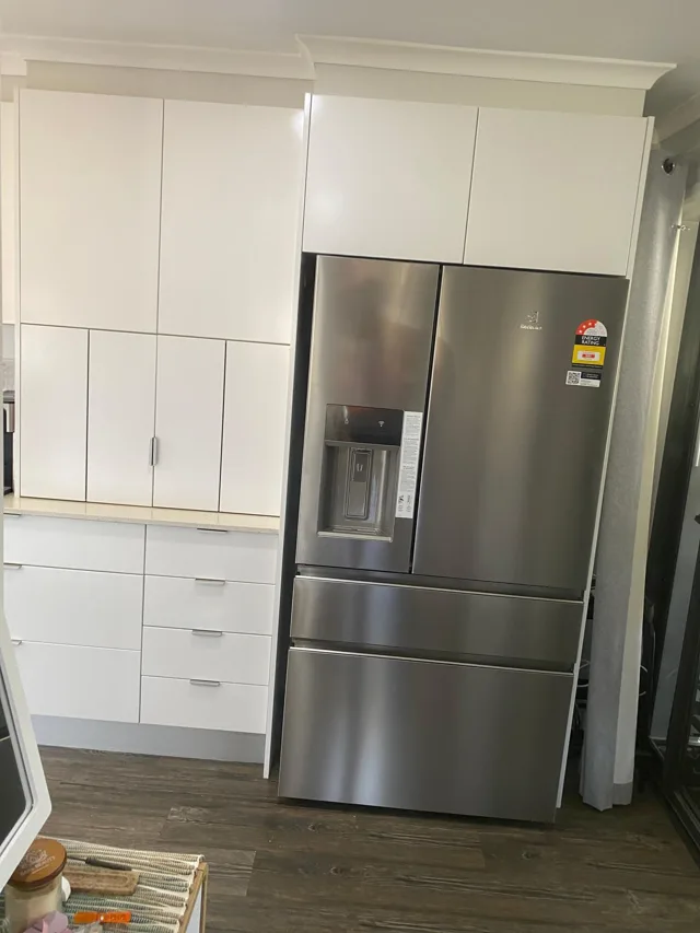 Plumbed fridge with a water dispenser in a fitted kitchen