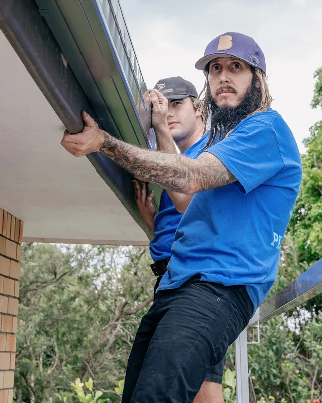 Jetty Plumbing team aligning guttering along a roof edge