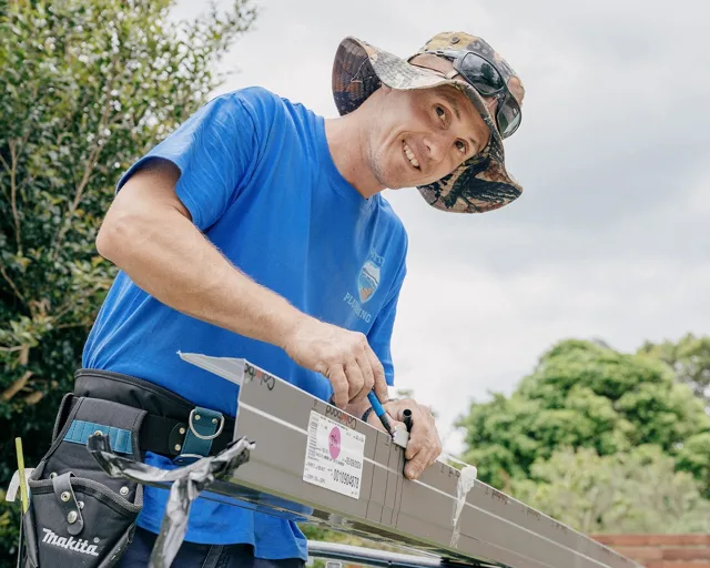 Jetty Plumbing team member preparing a gutter section for replacement