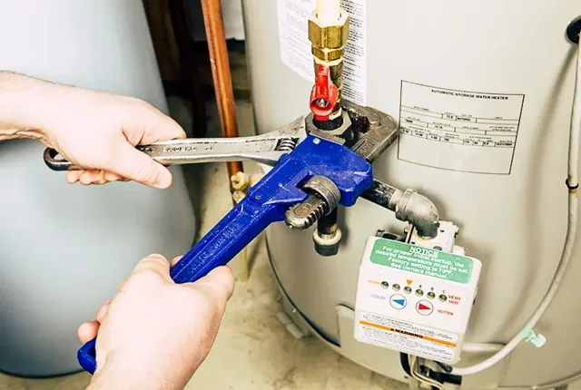 Plumber working on a hot water system’s pipe connections