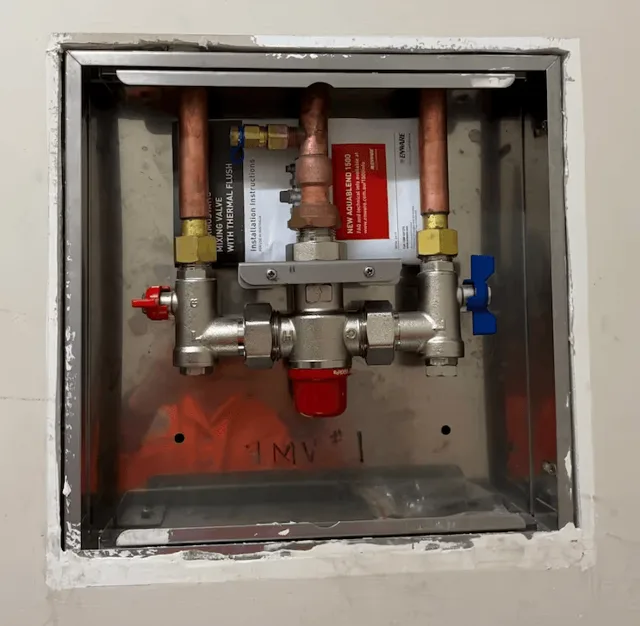 Thermostatic mixing valve inside a wall access box